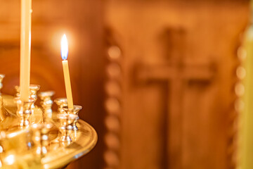 Image depicts a group of candles in a religious or ceremonial setting, with two blue-flamed candles...
