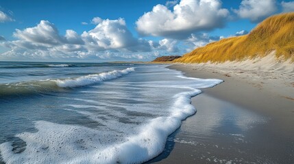 A serene beach scene with gentle waves and golden dunes under a blue sky.