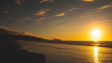Sunning sunset sun setting into sea ocean water kapiti coast new zealand gold colour