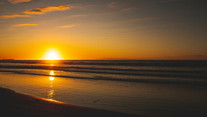 Sunning sunset sun setting into sea ocean water kapiti coast new zealand gold colour