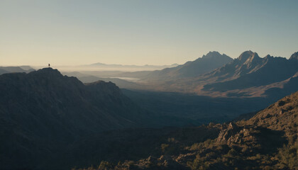 Fototapeta premium Majestic mountains tower over a serene valley at sunset in a remote wilderness location