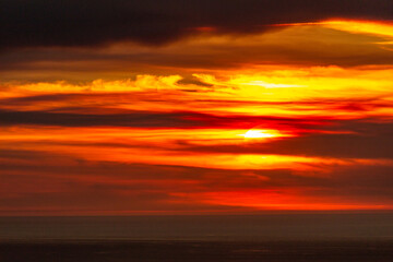 Sunset over the Atlantic Ocean. Dramatic Sky with Clouds and Sun