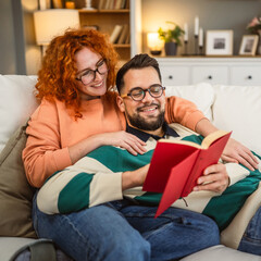 cheerful couple enjoy together on sofa and read book together