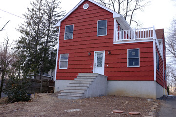 red suburban house under renovation in suburban neighborhood 