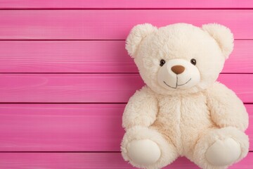 Obraz premium Cute and Cuddly Teddy Bear on Pink Wooden Background