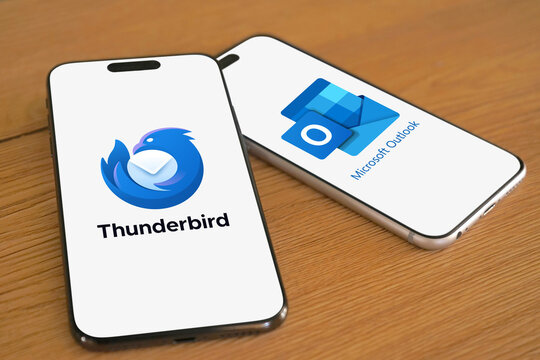 Thunderbird and Microsoft Outlook logos are displayed on two smartphones next to each other, e-mail client, with functions as calendaring, messages, contact managing, notes, organization, filter
