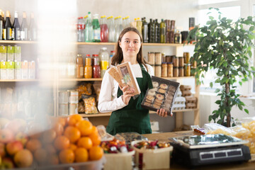 Teenage girl seller at counter offering sweets in grocery store..