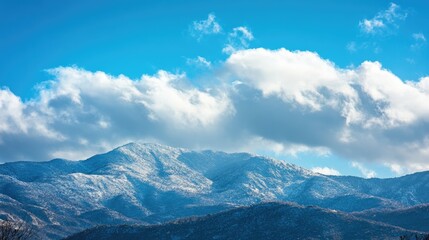Bright sunlight reflects off the pristine snow on the mountain range, creating a dazzling display.