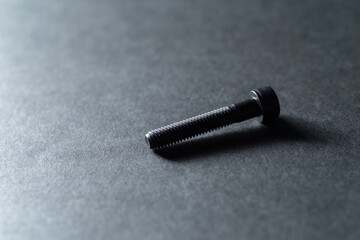 黒背景に置いてある沢山のネジ