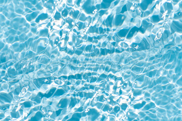 Blue water with ripples on the surface. Defocus blurred transparent blue colored clear calm water surface texture with splashes and bubbles. Water waves with shining pattern texture background.
