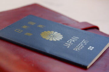 パスポート（5年用紺色）とシステム手帳（トラベラーズノート）で、海外旅行を計画しているイメージ
