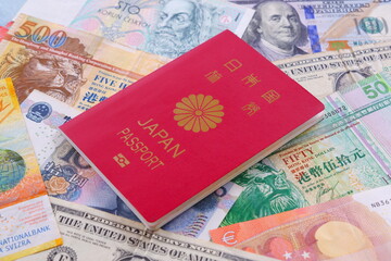 日本のパスポート（一般旅券10年用赤色）と海外のお金で、海外旅行のイメージ

