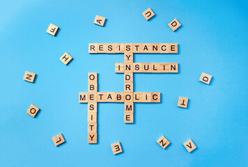 Words insulin resistance and metabolic syndrome made of wooden blocks with letters on blue...