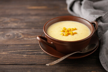 Delicious creamy corn soup in ceramic bowl on the table. Vegetarian food