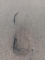 shoe prints on the beach sand in the morning
