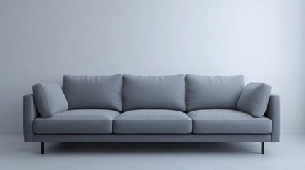 Fototapeta premium A gray couch with three cushions sits in a white room