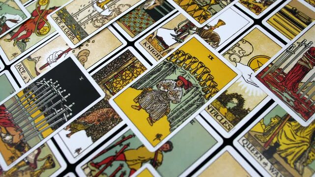 Tarot cards of the minor arcana spread out in a scattered arrangement, showcasing colorful illustrations and intricate designs symbols and themes used for divination and spiritual insight