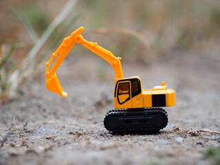 Naklejka premium Mini toy of excavator at outdoor with blurred background. Industrial photography concept design.