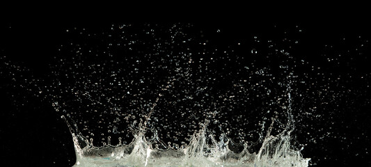 Crown water to object make curve drop explosion in ripple motion. Black background isolated. Crown Water splash on object to create shape form fluttering in droplet and wave.