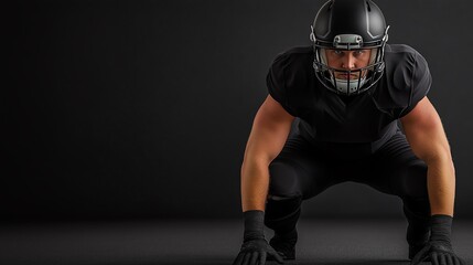 A focused football player in a black uniform prepares to make a powerful move on the field. The dramatic lighting highlights the athlete's determination and strength.
