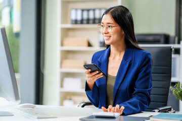 A businesswoman sits at her desk in a modern office, working on a laptop. She browses an online banking website, managing finances, analyzing transactions, and making strategic business decisions.