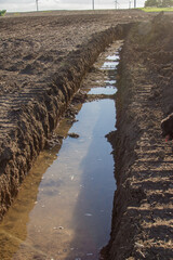 water filled trench in a field