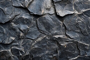 Dark grey stone texture, rough surface, cracked rock background.