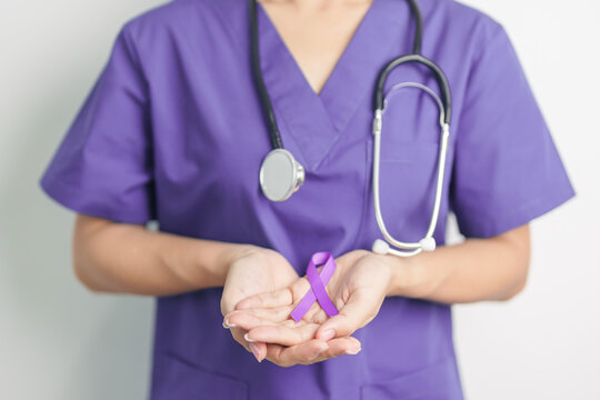 Doctor holding purple Ribbon for Violence, Pancreatic, Esophageal, Testicular cancer, Alzheimer, epilepsy, lupus, Sarcoidosis and Fibromyalgia. Awareness month and World cancer day concept - Powered by Adobe