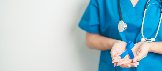 March Colorectal Cancer Awareness month, doctor with dark Blue Ribbon for supporting people living...