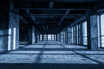 Expansive Industrial Interior Space with Dramatic Shadows and Light