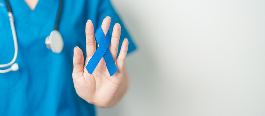 March Colorectal Cancer Awareness month, doctor with dark Blue Ribbon for supporting people living and illness. Healthcare, hope and World cancer day concept