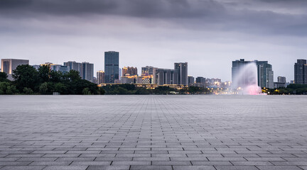 Fototapeta premium Urban City Skyline at Dusk with Scenic Fountain and Dramatic Clouds