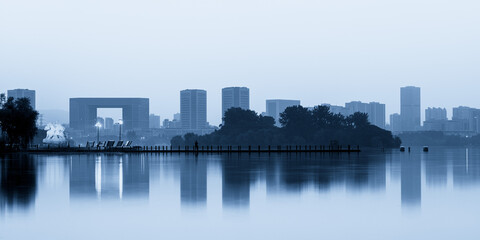 Obraz premium Serene Urban Landscape at Dawn Reflecting on Still Waters