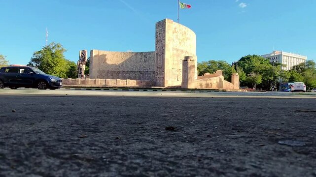 Monumento a la Patria en Paseo Montejo, M&eacute;rida, con calles, edificios y bandera de M&eacute;xico. Captura la vida urbana y belleza hist&oacute;rica de la ciudad de M&eacute;rida, Yucat&aacute;n.