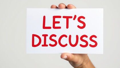 Hand Holding a Sign That Reads ,Let,s Discuss, in Bold Red Text Inviting Conversation