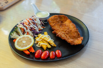Grilled fish steaks with vegetables salad on a plate.