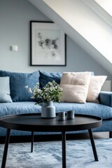 Scandinavian interior design of modern living room. Modern blue sofa with cushions and contemporary black round coffee table in a well-lit stylish living room.