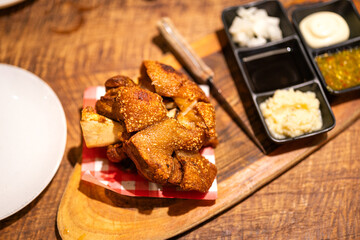 A crispy deep fired pork leg with various sauce that served on wooden plate. Food object top view photo, selective focus.