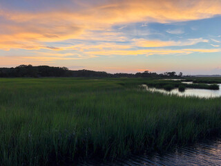 Vibrant Sunset over Marshland and Calm Waters