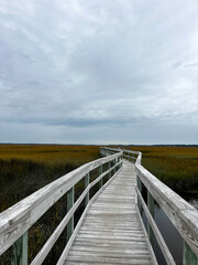 Naklejka premium Wooden Boardwalk Stretching through Marshland