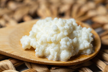 Bebida de kéfir fermentada con probióticos, granos kéfir sobre una cuchara de madera.