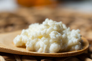 Bebida de kéfir fermentada con probióticos, granos kéfir sobre una cuchara de madera.