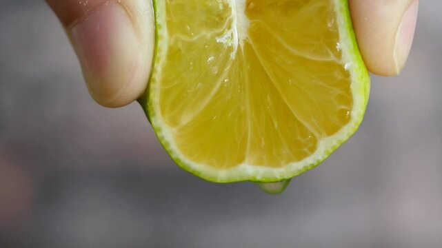 すっぱくてジューシーな柑橘。すだちの果汁を絞る動画。クローズアップ