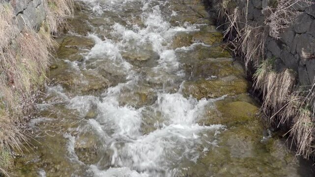 Water flows along an irrigation canal on a day in winter.