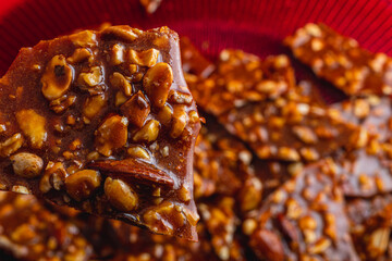 Homemade sugar cookies with nuts on a shiny red plate close up