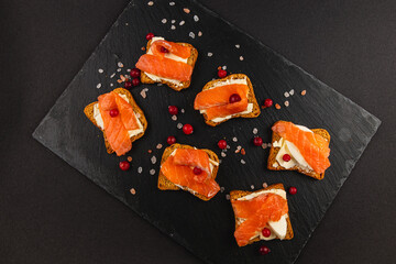 Salmon pieces on fresh toast spread with butter and a slice of mozzarella