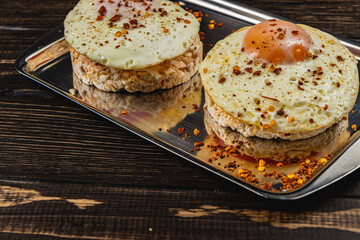 Sandwiches with egg on rice bread with tomato on a plate on a wooden background