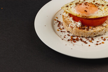 Egg sandwiches on rice bread on a white plate on a black background