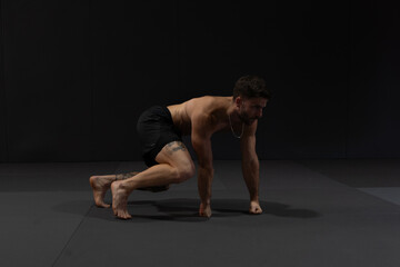 Obraz premium Personal trainer doing his indoor workout at the gym. His technique is called flow moves