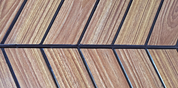 Close up view of Herringbone pattern of natural wood parquet wall texture background.
